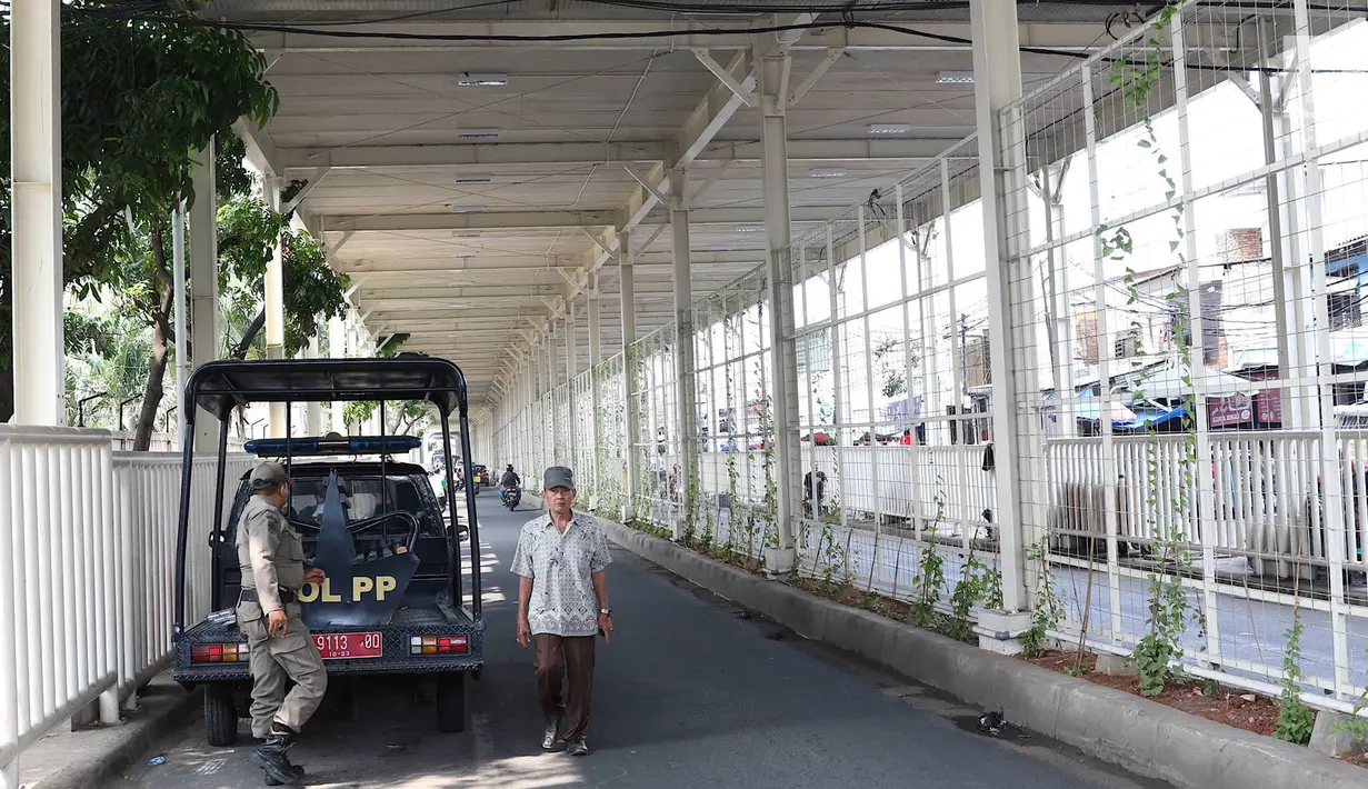 Personel Satpol PP berjaga di bawah skybridge Tanah Abang, Jakarta, Selasa (8/1). Penjagaan tersebut dilakukan untuk mencegah PKL yang berjualan di sekitar Stasiun Tanah Abang. (Liputan6.com/Immanuel Antonius)