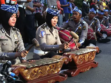 Sejumlah polisi wanita (polwan) memainkan alat musik tradisional, gamelan, pada kegiatan car free day di Jakarta, Minggu (9/4). Dalam atraksi tersebut mereka melakukan sosialisasi “Polwanku Sahabatku”. (Liputan6.com/Angga Yuniar)