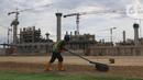 Pekerja melakukan perataan tanah di area lapangan latih Jakarta International Stadium, Jumat (23/10/2020). Nantinya lapangan latihan ini akan ditumbuhi rumput hybrid, yang memiliki komposisi 5 persen rumput sintetis dan 95 persen natural berjenis Zoysia Matrella. (Liputan6.com/Helmi Fithriansyah)