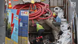 Pekerja menyelesaikan proyek galian kabel bawah tanah di tengah Jalan Gajah Mada, Jakarta, Senin (11/6). Proyek ini tahapan konstruksinya telah mencapai 48% atau setara dengan 16.994 MW pada Maret 2018. (Liputan6.com/Immanuel Antonius)