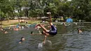 Orang-orang mendinginkan tubuh di sungai di tengah gelombang panas di Paraguari, Paraguay, Minggu (16/1/2022). Suhu Paraguay secara umum mencapai 41 derajat celsius. (AP Photo/Jorge Saenz)