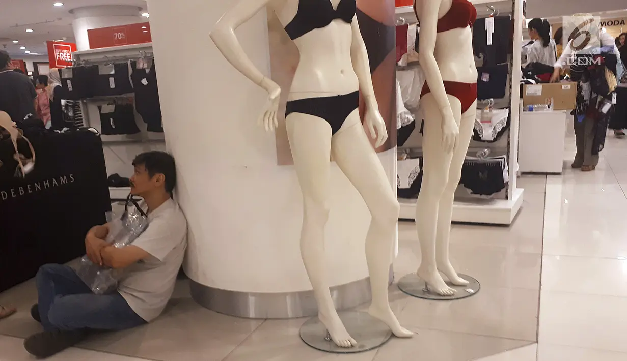 Pembeli duduk di stan pakaian dalam wanita saat midnight sale di gerai Debenhams, Senayan City, Jakarta, Sabtu (30/12). PT Mitra Adiperkasa Tbk (MAP) menutup gerai Debenhams dengan diskon besar-besaran di akhir tahun 2017. (Liputan6.com/Fery Pradolo)