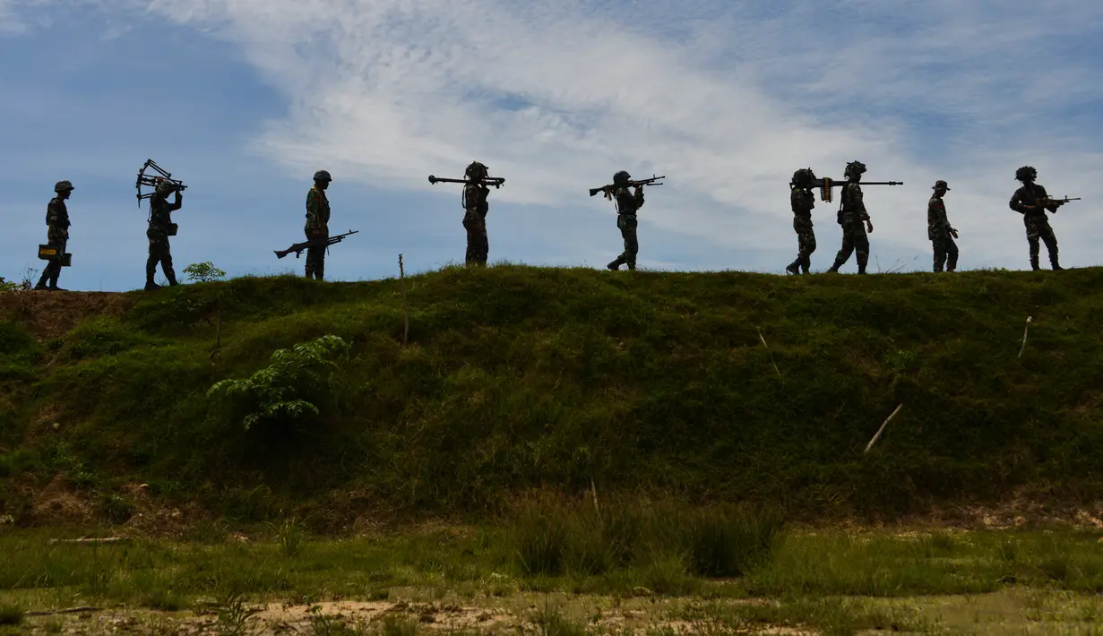 Sejumlah prajurit TNI dari batalyon infantri Raider 112 berjalan membawa berbagai senjata selama latihan menembak di Mata Ie, Aceh Besar, Aceh, Selasa (11/6/2019). Latihan menembak ini untuk memelihara dan meningkatkan kemampuan prajurit Raider.  (AFP Photo/Chaideer Mahyuddin)