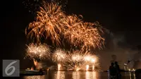 Warga menyaksikan atraksi kembang api perayaan tahun baru 2017 di Pantai Lagoon, Ancol, Jakarta (1/1). Antusiasme warga menyambut tahun 2017 diramaikan dengan pesta kembang api di sejumlah sudut Ibu Kota. (Liputan6.com/Gempur M. Surya)
