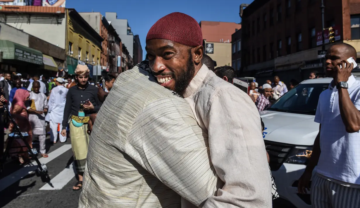 Umat muslim salib berpelukan usai melaksanakan salat Idul Fitri di luar Masjid at-Taqwa, Brooklyn, New York City, Amerika Serikat, Selasa (4/6/2019). Ribuan umat muslim melaksanakan salat Idul Fitri di jalanan New York City. (Stephanie Keith/Getty Images North America/AFP)