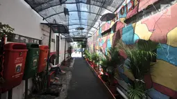 Aktivitas warga di gang di RT 13 RW 06, Jembatan Lima, Jakarta, Kamis (10/1). Warna-warni mural di pemukiman padat penduduk itu merupakan ide Aryanto selaku Ketua RT 13. (Merdeka.com/Iqbal Nugroho)