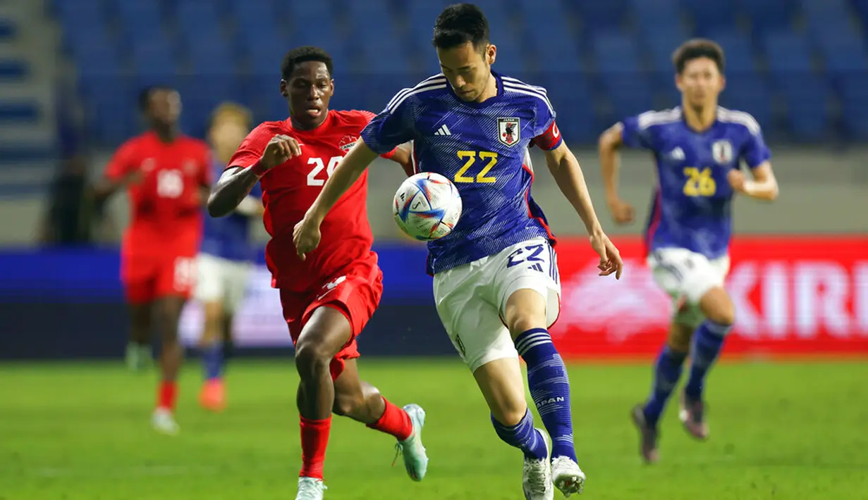 Pemain Kanada Jonathan David (kiri) berebut bola dengan pemain Jepang pada pertandingan persahabatan di Dubai, 17 November 2022. Kanada mengalahkan Jepang dengan skor 2-1. (AP Photo/Christopher Pike)