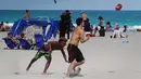Orang-orang bersenang-senang di pantai di Miami, Florida pada Selasa (16/3/2021). Mahasiswa telah tiba di daerah Florida Selatan untuk liburan musim semi tahunan. Para pejabat kota prihatin dengan kerumunan liburan musim semi saat pandemi COVID-19 terus berlanjut. (Joe Raedle/Getty Images/AFP)