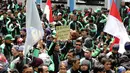 Pengemudi ojek on-line GrabBike mengangkat tulisan tuntutan saat unjuk rasa di belakang kantor Grab di kawasan Kuningan, Jakarta, Kamis (5/1). Mereka menuntut pihak perusahaan menaikkan tarif argo per kilometernya. (Liputan6.com/Helmi Fithriansyah)