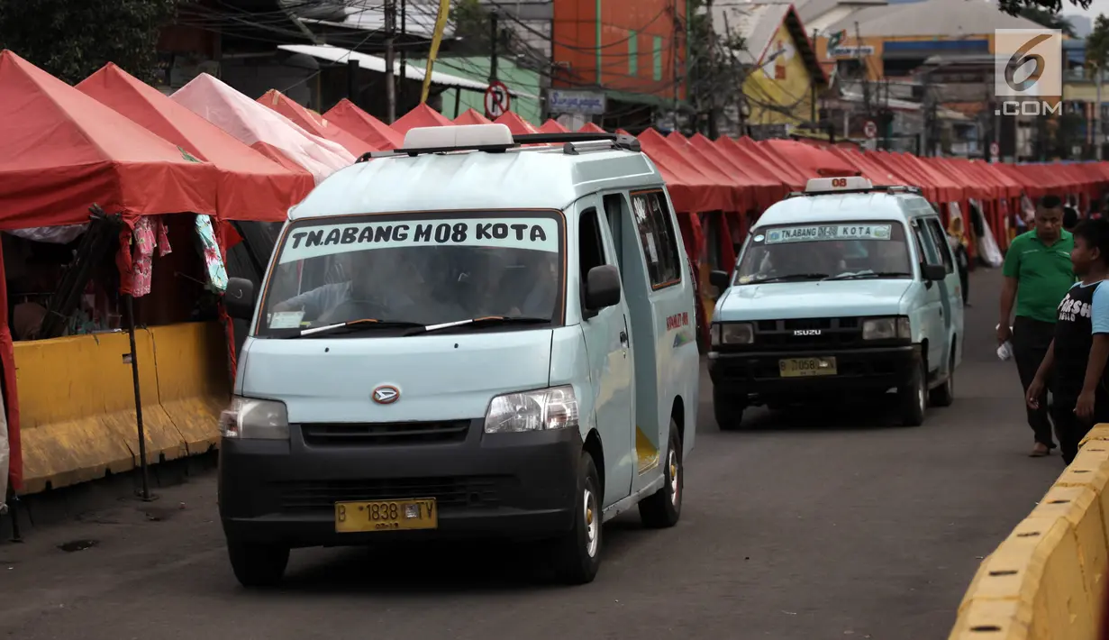 Sejumlah angkutan kota Tanah Abang melintasi Jalan Jatibaru Raya, Jakarta, Sabtu (3/2). Angkot hanya diperbolehkan melintas di satu ruas jalan saja, depan Stasiun Tanah Abang dan satu ruas lagi tetap digunakan PKL berjualan. (Liputan6.com/Arya Manggala)