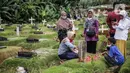Umat Muslim menabur bunga saat di makam keluarga saat berziarah di Tempat Pemakaman Umum (TPU) Pondok Ranggon, Jakarta, Minggu (04/04/21). Meskipun di tengah pandemi Covid-19 warga tetap melakukan tradisi ziarah kubur. menjelang bulan Ramadan. (Liputan6.com/Faizal Fanani)