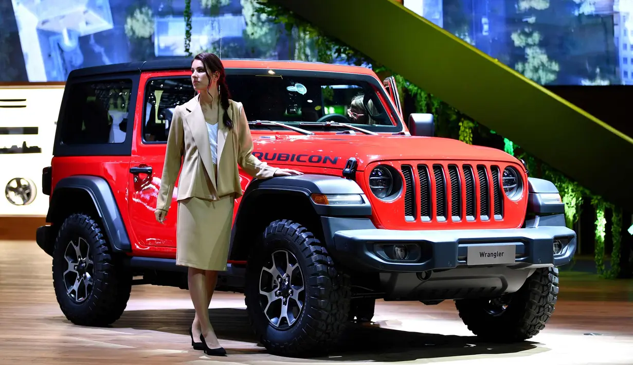 Seorang model berpose di samping mobil Jeep selama Geneva International Motor Show di Jenewa, Swiss (6/3). Pameran otomotif ini berlangsung dari 8 sampai 18 Maret 2018. (AFP Photo/Harold Cunningham)