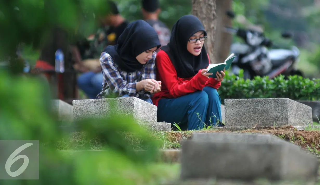Warga membaca doa dimakam TPU Karet Bivak, Jakarta (2/2). Dinas Pertamanan dan Pemakaman telah menerapkan sistem online dalam pelayanan pemakaman di Ibu kota dengan alamat situs pertamananpemakaman.jakarta.go.id. (Liputan6.com/Gempur M Surya)