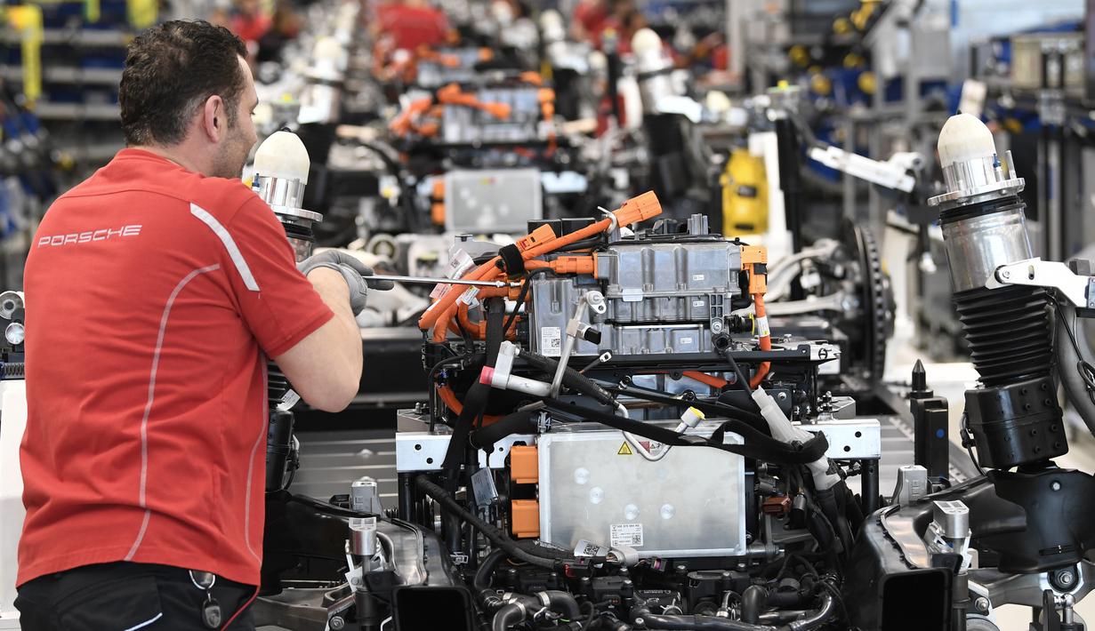 Mekanik melakukan pemasangan sasis dan unit baterai mobil listrik Porsche Taycan saat proses perakitan di pabrik perusahaan Porsche AG di Stuttgart, Jerman, Rabu (4/3/2020). Porsche Taycan merupakan mobil bertenaga listrik pertama  dari pembuat mobil mewah Jerman, Porsche AG. (AFP Photo/Thomas Kienz