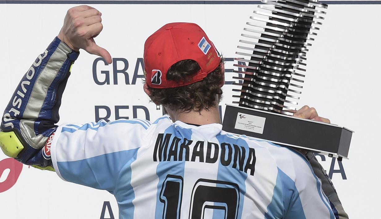 Valentino Rossi mengenakan jersey tim sepak bola Argentina saat merayakan kemenangkan MotoGP di sirkuit Termas de Rio Hondo, Argentina  pada April 2015. (AFP/Juan Mabromata)