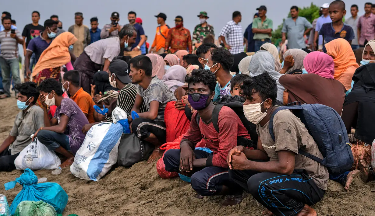 Pengungsi etnis Rohingya beristirahat setelah tiba di pesisir pantai Lancok, di Kabupaten Aceh Utara, Kamis (25/6/2020). Nelayan Indonesia menemukan hampir 100 orang etnis Rohingya, termasuk 30 orang anak-anak terdampar di tengah laut dengan kondisi kapal rusak. (AP Photo/Zik Maulana)
