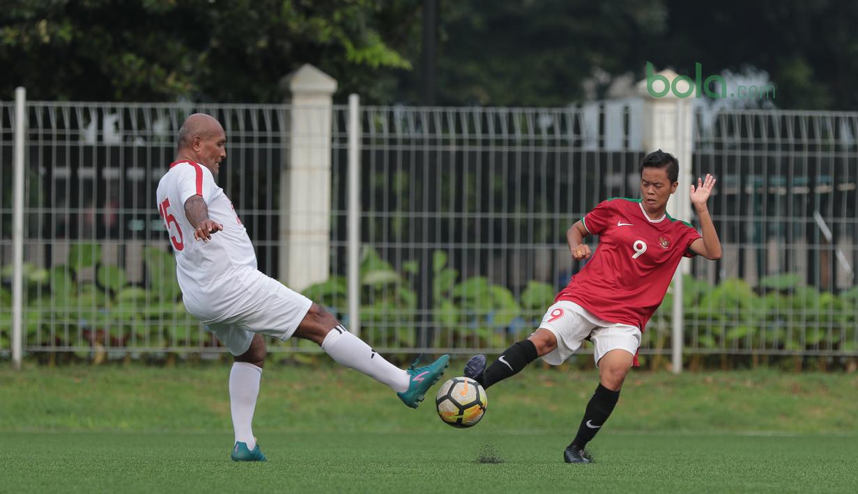 Pemain Timnas Wanita Indonesia, Mayang (kanan) berebut bola dengan pemain Legenda Indonesia pada laga uji coba di Lapangan ABC Senayan, Jakarta, Kamis (5/4/2018). Timnas Wanita Indonesia menang 3-2. (Bola.com/Nick Hanoatubun)