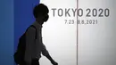 Seorang pria yang mengenakan masker pelindung untuk membantu mengekang penyebaran virus corona berjalan di depan logo Olimpiade Tokyo 2020 di Tokyo, Selasa (22/6/2021). Ibu kota Jepang mengkonfirmasi lebih dari 430 kasus virus corona baru pada hari Selasa. (AP Photo/Eugene Hoshiko)