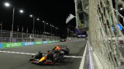 Pebalap Red Bull, Sergio Perez melewati garis finish saat Formula 1 GP Arab Saudi 2023 yang berlangsung di Jeddah Corniche Circuit, Senin (20/03/2023) WIB. (AP Photo/Pool/Luca Bruno)