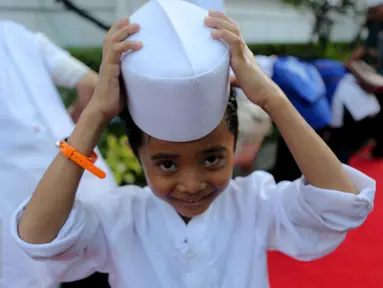 Seorang anak yatim terlihat tersenyum usai mengambil air wudhu, Jakarta, Kamis (18/6/2015). Jokowi mengundang 400 anak yatim dari 12 panti asuhan yang ada di Jabodetabek untuk berbuka puasa bersama di Isatana Negara (Liputan6.com/Faizal Fanani)