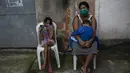 Fabiana Gomes dos Santos menunggu perawatan medis bersama kedua anaknya di favela Chapadao, Rio de Janeiro, Brasil, 17 Oktober 2020. Berdasarkan data Worldometers pada 19 Oktober 2020, jumlah kasus COVID-19 di Brasil sebanyak 5.235.344. (AP Photo/Bruna Prado)