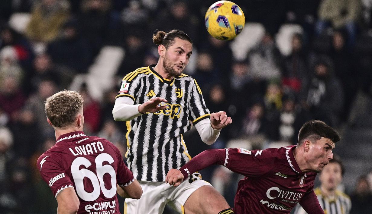 Gelandang Juventus, Adrien Rabiot (tengah) menyundul bola di antara dua pemain Salernitana pada laga babak 16 besar Coppa Italia 2023/2024 di Juventus Stadium, Turin, Jumat (5/1/2024) dini hari WIB. (dpa via AP Photo/Marco Alpozzi)