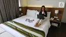 Tamu hotel bekerja di kamar dengan paket isolasi mandiri di Hotel Grand Whiz Poins Simatupang, Jakarta, Kamis (16/4/2020). Paket isolasi mandiri ditawarkan kepada orang  yang dalam keadaan sehat di kamar tipe Superior selama pandemi Corona (Covid-19). (Liputan6.com/Fery Pradolo)