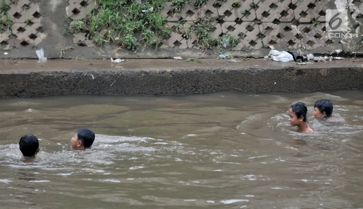 Anak-anak berenang di Kali Ciliwung, Kampung Pulo, Jakarta, Minggu (27/1). Keterbatasan ekonomi menjadikan Kali Ciliwung sebagai tempat pilihan bagi anak-anak setempat untuk menghabiskan waktu bermain saat libur sekolah. (Merdeka.com/Iqbal Nugroho)