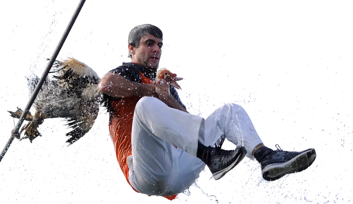 Ekspresi peserta saat mengikuti perayaan "Antzar Eguna" (Hari Angsa) di pelabuhan desa Basque Lekeitio, Spanyol (5/9). Dalam festival ini peserta harus bergelayutan pada tali dengan berpegangan pada kepala seekor angsa. (AFP/Ander Gillenea)
