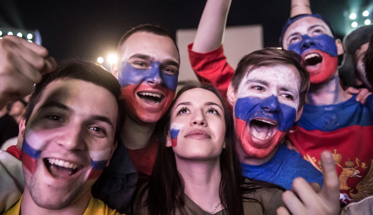 Suporter timnas Rusia merayakan kemenangan atas Mesir pada putaran kedua pertandingan grup A Piala Dunia di Moskow, Rabu (20/6). Tuan rumah Piala Dunia, Rusia mengamankan posisi mereka berkat kemenangan 3-1 atas Mesir. (KHALED DESOUKI / AFP)