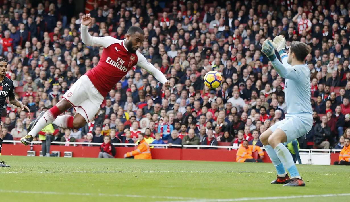 Striker Arsenal, Alexandre Lacazette, melepaskan sundulan ke gawang Swansea City pada laga Premier League di Stadion Emirates, Sabtu (28/10/2017). Arsenal menang 2-1 atas Swansea City. (AP/Frank Augstein)