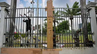 Para pekerja memasang kembali pagar besi kompleks parlemen yang dijebol oleh para demonstran pada hari sebelumnya, di Jakarta pada 23 Agustus 2024. (BAY ISMOYO/AFP)