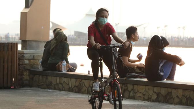 Pengunjung menikmati suasana Pantai Ancol, Jakarta, menjelang berlakunya PSBB, Sabtu (12/9/2020). Pemprov DKI berencana menutup sejumlah tempat rekreasi di antaranya Ancol, Ragunan, Monas, dan Taman Mini Indonesia Indah saat PSBB total pada 14 September mendatang. (Liputan6.com/Herman Zaharia)