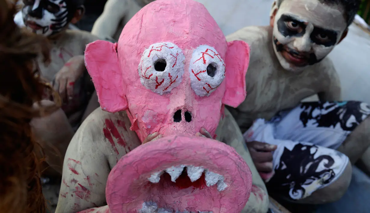 Peserta dengan memakai topeng bersuka ria mengikuti parade " La Calabiuza " di El Savador, Minggu (1/11/2015). " La Calabiuza " oleh warga Tonacatepeque diartikan sebagai Hari Kematian. (AFP PHOTO/Marvin RECINOS)
