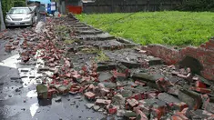 Seorang pria berjalan di antara reruntuhan batu bata sebuah dinding yang hancur akibat Topan Matmo, Taiwan, Rabu (23/7/14). (REUTERS/Pichi Chuang)