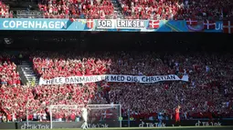 Suporter timnas Denmark memasang spanduk untuk Christian Eriksen pada laga grup B Euro 2020 di stadion Parken, Kopenhagen, Kamis (17/6/2021). Duel Denmark vs Belgia berhenti sejenak pada menit ke-10 untuk memberi penghormatan kepada bintang timnas Denmark, Christian. (Wolfgang Rattay, Pool via AP)