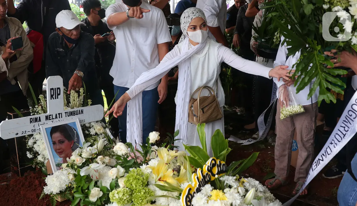 Kerabat dan keluarga meletakkan bunga di atas makam aktris senior Rima Melati di TPU Tanah Kusir, Jakarta Selatan, Sabtu (25/6/2022). Setelah prosesi pemakaman, keluarga dan kerabat meletakkan berbagai karangan bunga sebagai ucapan belasungkawa terakhir kepada Rima Melati. (Liputan6.com/Angga Yuniar)