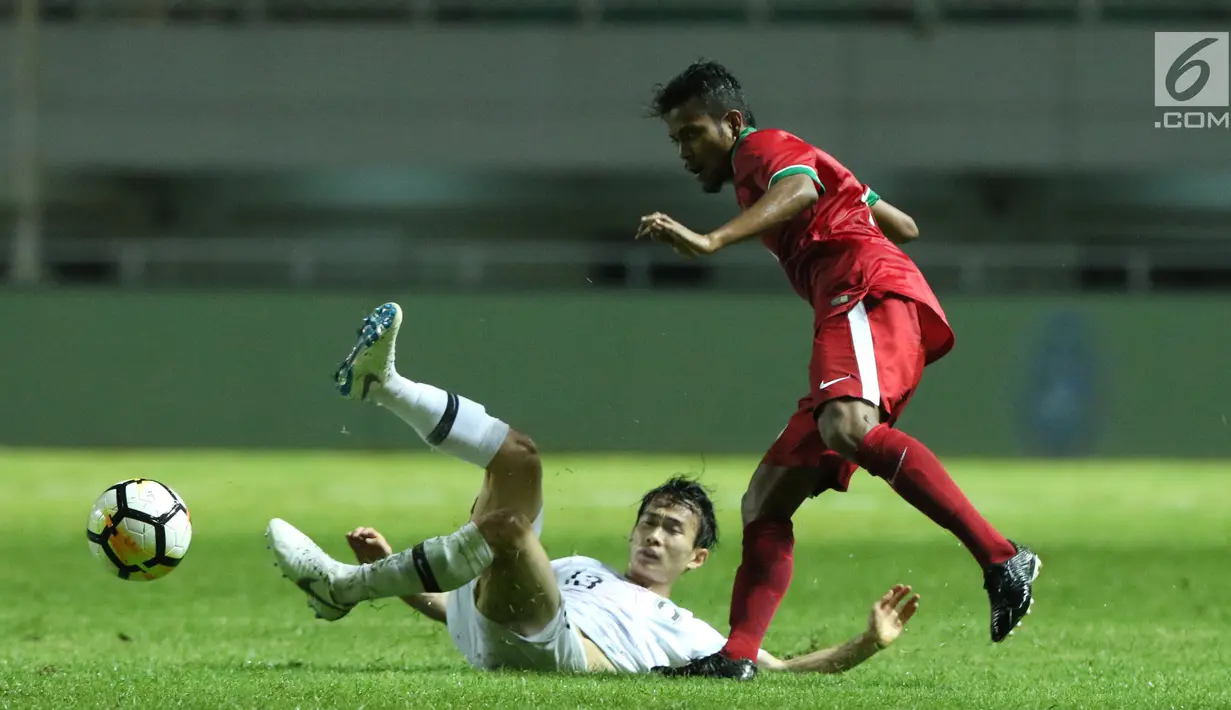 Gelandang timnas Indonesia U-23, Zulfiandi (kanan) mencoba melewati adangan pemain Korea Selatan U-23, Kim Moohwan pada laga persahabatan di Stadion Pakansari, Kab Bogor, Sabtu (23/6). Indonesia U-23 kalah 1-2. (Liputan6.com/Helmi Fithriansyah)