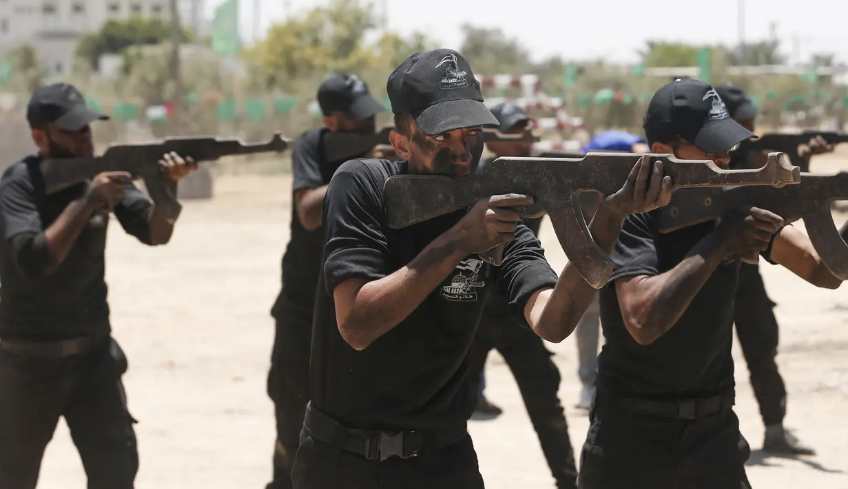 Sejumlah kadet Palestina berlatih menembak dengan militer Hamas, Brigade Ezzedin al-Qassam, di Kota Gaza (20/7/2019). Serangkaian tes militer pun harus dilakukan para kadet yang dimulai dari uji fisik, ketangkasan hingga menembak. (AFP Photo/Mahmud Hams)