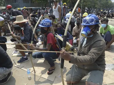 Pengunjuk rasa anti-kudeta menyiapkan busur dan anak panah darurat untuk menghadapi polisi di kota Thaketa Yangon, Myanmar  (27/3/2021).  Kepala junta Myanmar menggunakan kesempatan Hari Angkatan Bersenjata untuk mencoba membenarkan penggulingan pemerintahan terpilih Aung San Suu Kyi. (AP Photo)