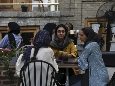Sejumlah wanita berbincang saat menikmati sore hari di sebuah kafe di pusat kota Teheran, Iran (10/8/2019). Taheran merupakan ibu kota Iran yang memiliki populasi 8.000.000 (metropolitan: 10.000.000). (AP Photo/Vahid Salemi)