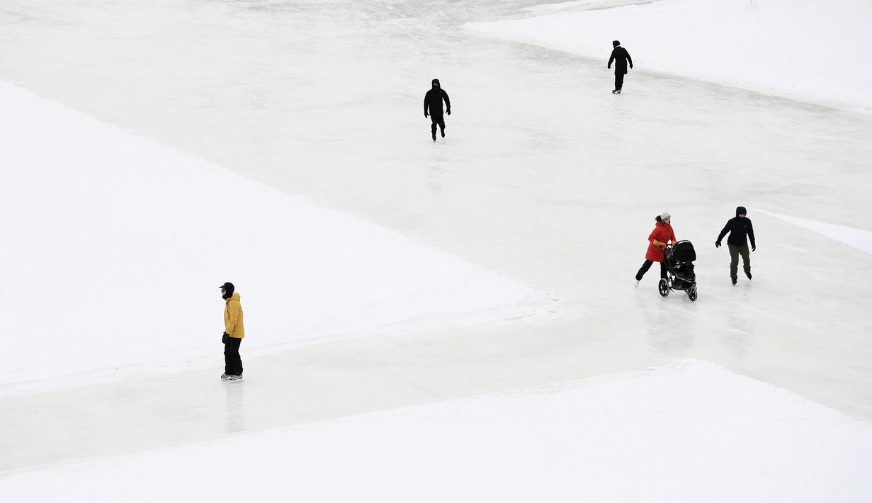 Orang-orang menyusuri Rideau Canal Skateway pada hari pembukaannya di tengah pandemi COVID-19 di Ottawa, Ontario, Kamis (28/1/2021). Kanal Rideau adalah Situs Warisan Dunia UNESCO. (Justin Tang/The Canadian Press via AP)