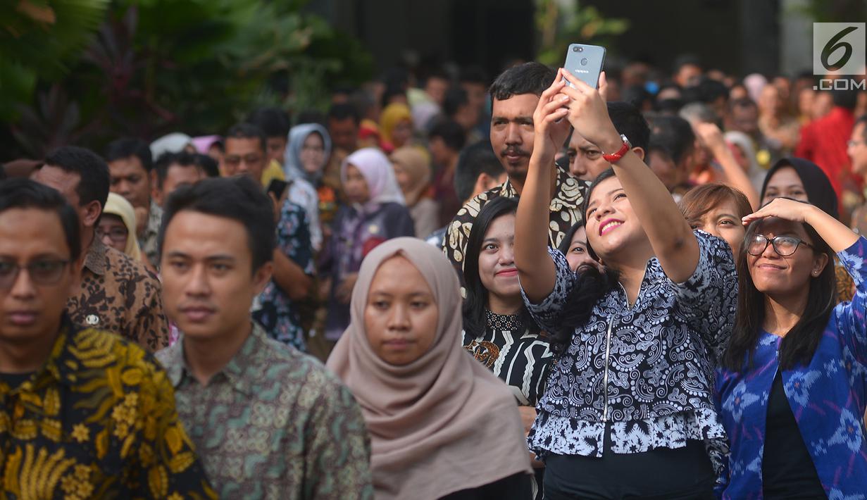 Pegawai Pemprov DKI berswafoto saat mengantre di Balai Kota, Jakarta, Kamis (21/6). Gubernur dan Wakil Gubernur DKI Jakarta, Anies Baswedan-Sandiaga Uno menggelar halalbihalal pada hari pertama masuk kerja setelah libur Lebaran. (Merdeka.com/Imam Buhori)