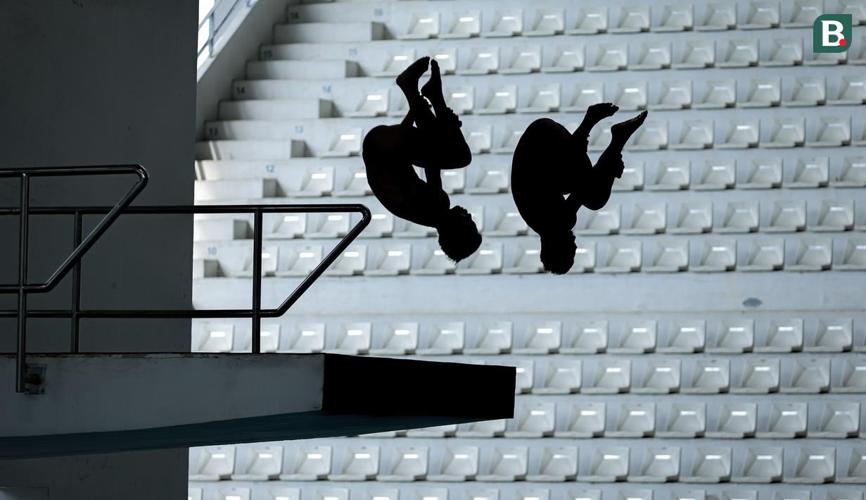 Siluet pasangan atlet loncat indah, Andriyan (kanan) dan Adityo Restu Putra saat beraksi pada nomor menara synchro putra Kejurnas Akuatik 2026 di Stadion Akuatik Gelora Bung Karno, Senayan, Jakarta, Selasa (05/05/2026). (Bola.com/Bagaskara Lazuardi)