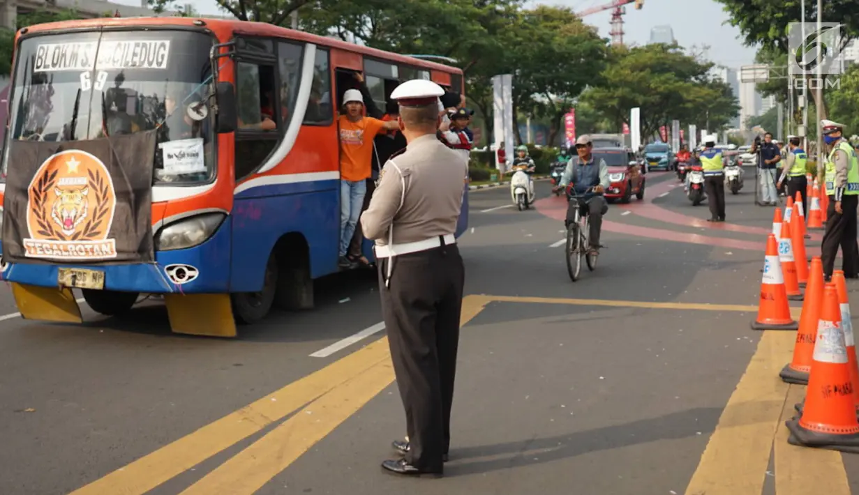 Petugas kepolisian mengatur arus lalu lintas kendaraan di sekitar SUGBK Senayan, Jakarta, Rabu (10/7/2019). Banyaknya kendaraan suporter Persija yang ingin menonton pertandingan membuat sejumlah arus lalu lintas dialihkan untuk mengurai kemacetan. (Liputan6.com/Immanuel Antonius)