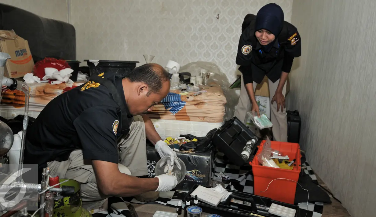 Petugas labfor Polda Metro melakukan pengujian bahan yang diduga digunakan untuk membuat sabu, Jakarta (25/7). Kepolisian Polda Metro Jaya menggerebek sebuah gudang yang diduga pabrik narkoba jenis sabu di kawasan Penjaringan. (Liputan6.com/Yoppy Renato)