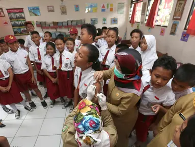 Siswa SD menunggu giliran untuk disuntik difteri di sebuah sekolah dasar di Tangerang,  Senin (11/12). Indonesia memulai sebuah kampanye untuk mengimunisasi 8 juta anak-anak dan remaja dari difteri. (AP Photo / Tatan Syuflana)
