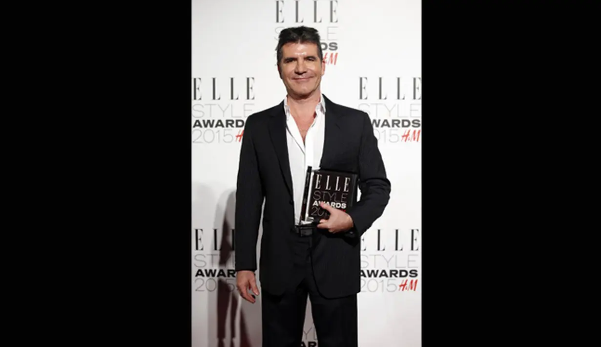 Simon Cowell berpose dengan penghargaannya sebagai 'Outstanding Contribution to Entertainment' dalam ajang Elle Style Awards 2015, London, Selasa (24/2). (AFP PHOTO/Justin Tallis)