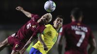Bek Venezuela, Roberto Rosales menyundul bola saat bersaing dengan penyerang Brasil, Roberto Firmino dalam laga Kualifikasi Piala Dunia 2022 Zona Amerika Selatan, di Estadio Morumbi, Sao Paulo, Brazil, Jumat (13/11/2020). Brasil berhasil mengalahkan Venezuela 1-0. (Fernando Bizerra/Pool via AP)