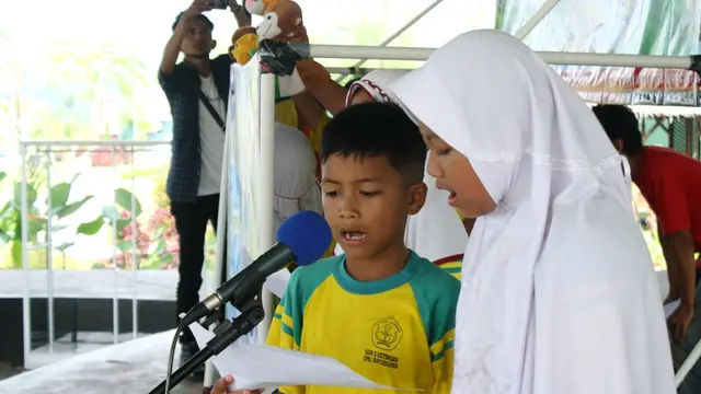 Anak-anak membacakan dongeng tentang penyelamatan sumber daya air dalam peringatan hari air sedunia. (Foto: Liputan6.com/Muhamad Ridlo)